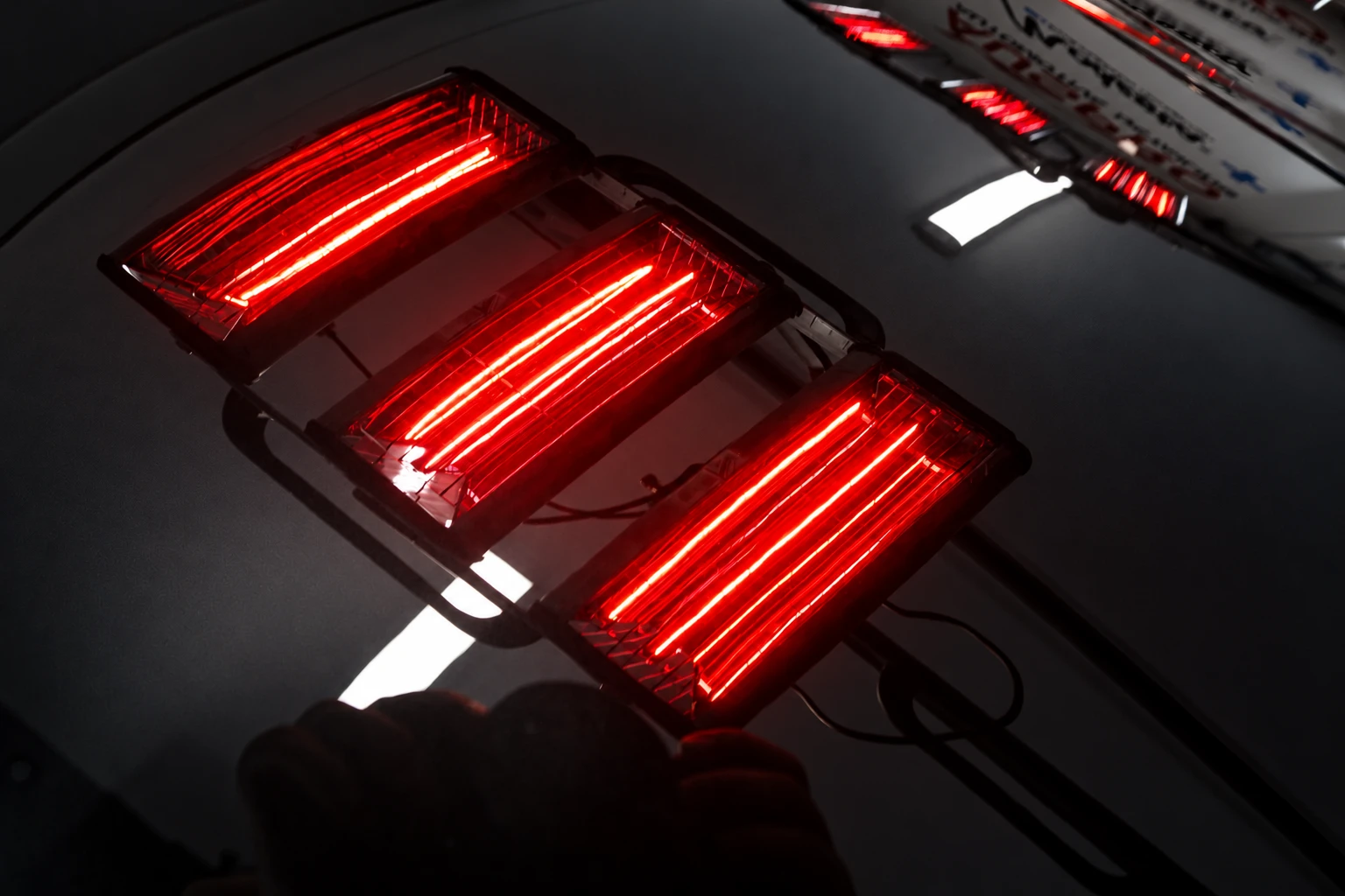 Short-wave infrared curing lamps reflected in coated black paint at AusPro Detailing