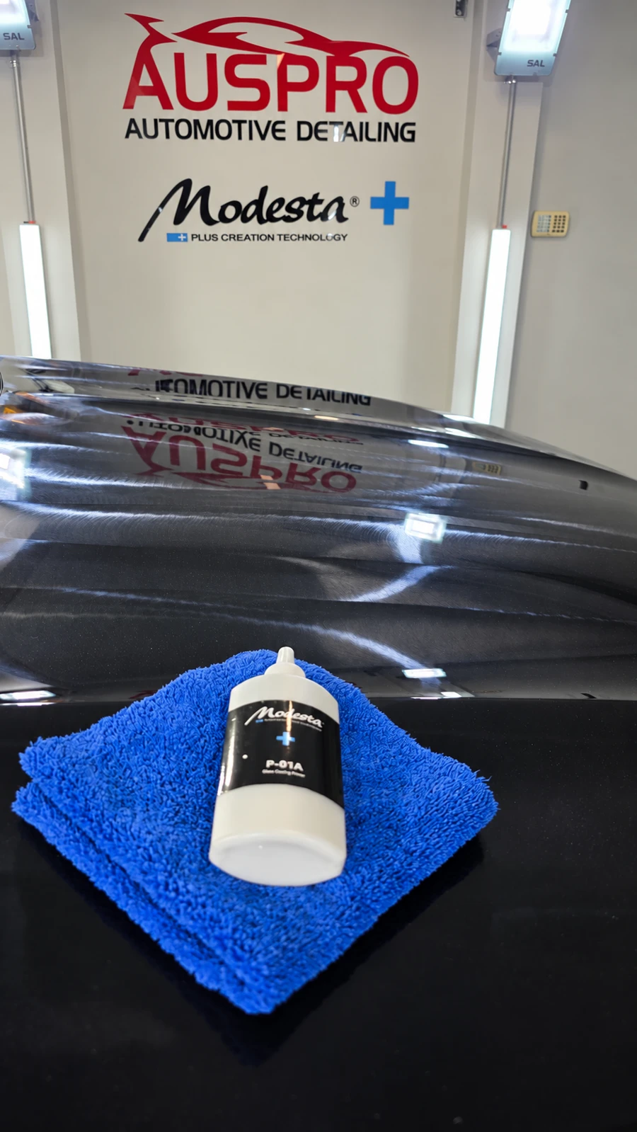 Modesta P-01A primer application in progress on a black bonnet in the AusPro Detailing Greystanes workshop